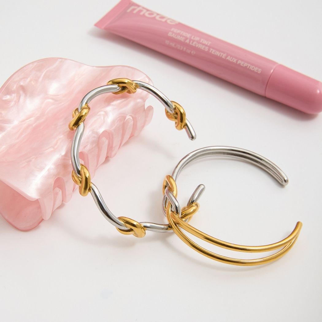 Gold and silver Entwined Knot cuffs styled with a pink accessory