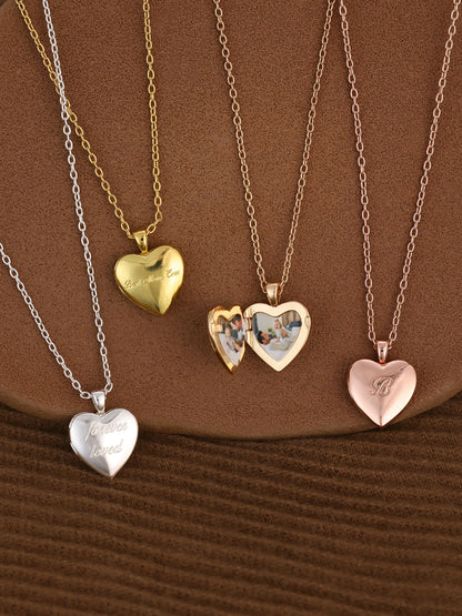 Four heart-shaped pendants on gold chains against a brown background