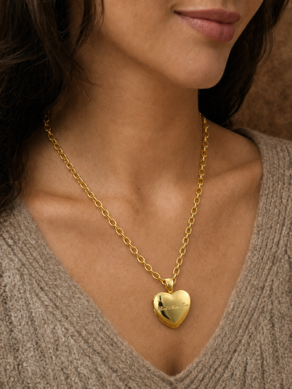 Model wearing the engraved gold heart locket on its oval-link chain